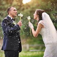 Hochzeitspaar pustet Löwenzahnblüten