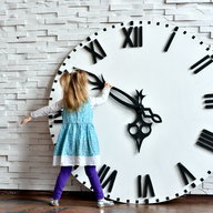 kleines mädchen dreht an einer großen uhr die zeiger