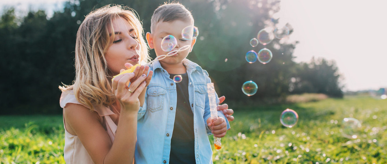 Mutter mit Sohn Seifenblasen blasen