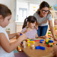 Kindergärtnerin und Kinder spielen