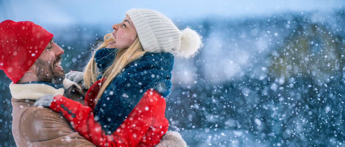 Pärchen freut sich im fallenden Schnee