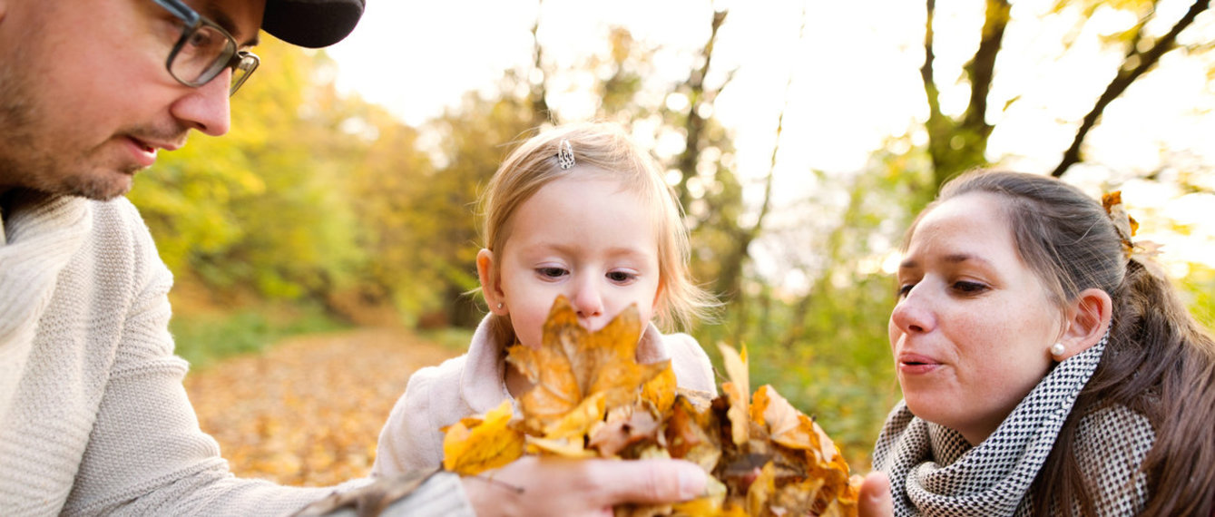 Junge Familie bewundert Herbstlaub im Wald