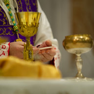 Pfarrer hält Hostie