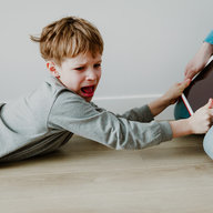 Kind liegt schreiend am Boden