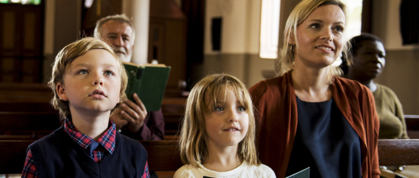 Mutter und Kinder in der Kirchenbank