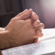 Bibel und gefaltene Hände