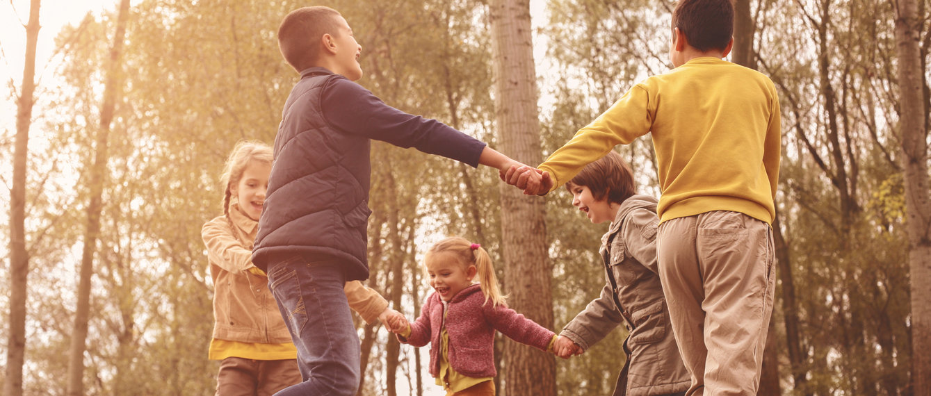 kleine Gruppe von Kindern tanzen im Wald