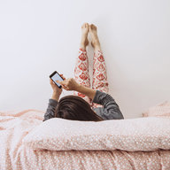 Mädchen am Handy im Bett