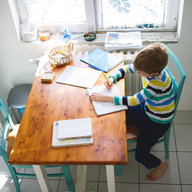 Kind lernt am Esstisch