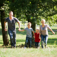 Junge Familie läuft über Wiese