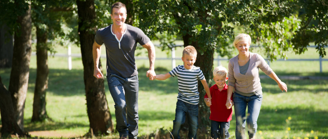 Junge Familie läuft über Wiese