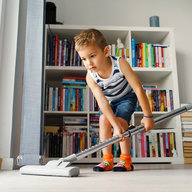 Kleiner Bub mit Staubsauger