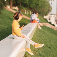 Kind schaut bei Schönwetter ins Mobiltelefon