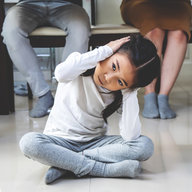 Tochter traurig unter Esstisch