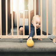 Baby hinter Schutzgitter