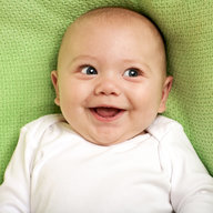 Baby liegt und lacht