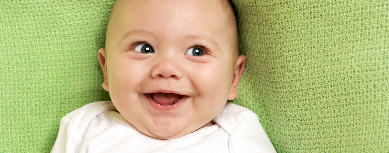 Baby-Zeichen-Sprache © iStock Baby liegt und lacht