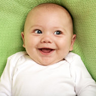 Baby-Zeichen-Sprache © iStock Baby liegt und lacht