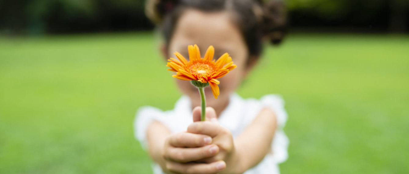 Kleinkind hält Blume in der Hand