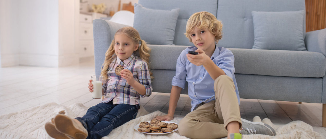 Geschwister vor der Couch beim Fernsehen