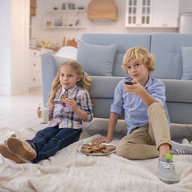 Geschwister vor der Couch beim Fernsehen