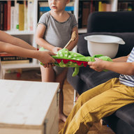 Junge und Mädchen streiten sich um ein Spielzeug 