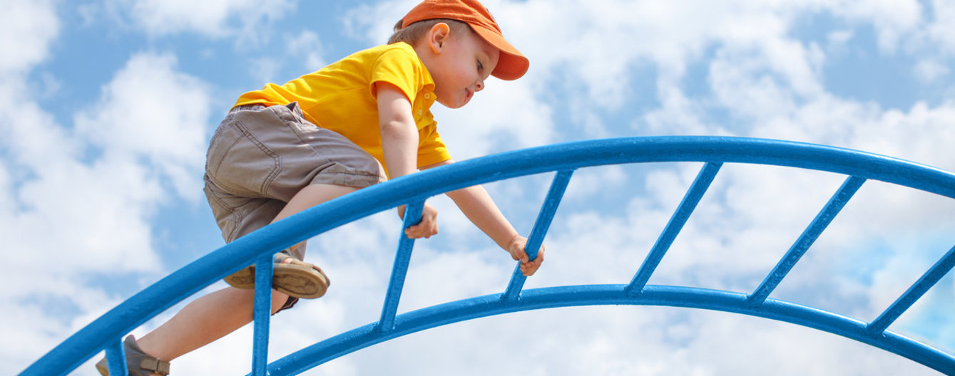 Kinder stärken - iStock © iStock Kleiner Bub klettert über ein Klettergerüst