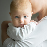 Mutter hält Neugeborenes Sicher im Arm