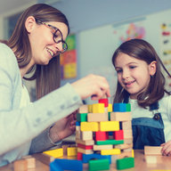 Tagesmutter spielt mit Kind