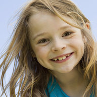 Mädchen mit Zahnlücke lächelt fröhlich