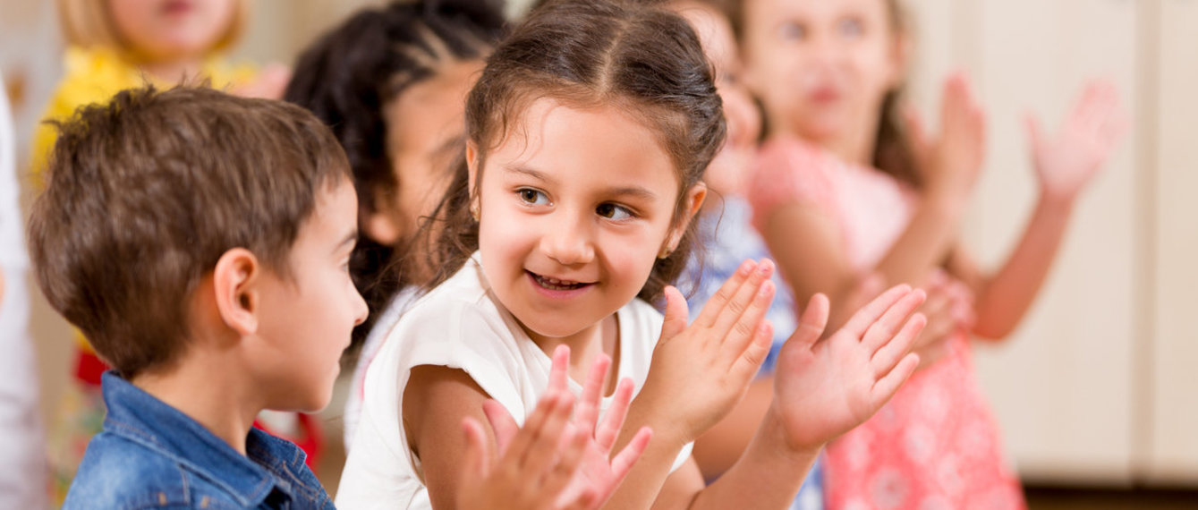 Kindergartenkinder klatschen in die Hände