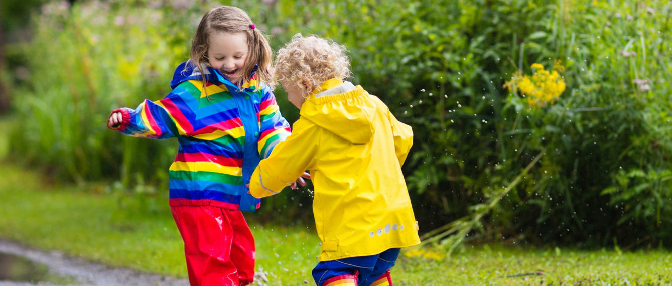 2 Kinder spielen in einer Pfütze