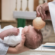 Baby wird von Priester getauft