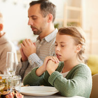 Familie betet vor Essen