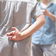 Kind kreuzt seine Finger