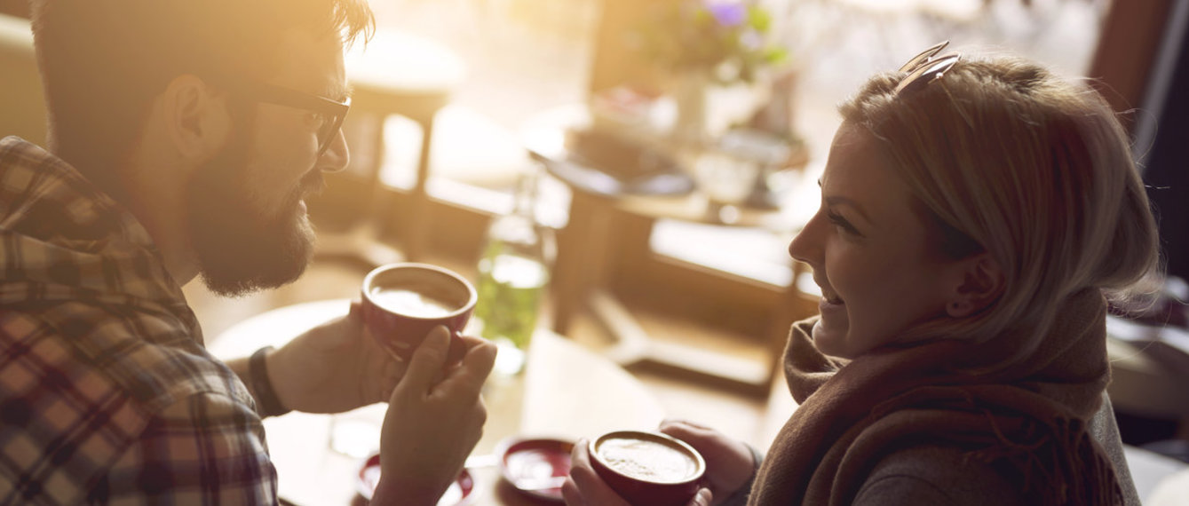 Glückliches Paar trinkt Kaffee und schaut sich an