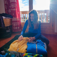 Frau packt Skigewand in Koffer