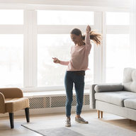Frau tanzt im Wohnzimmer
