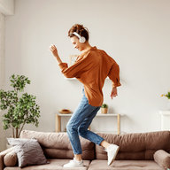 Frau tanzt auf Couch zuhause