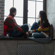 Paar sitzt beim Fenster