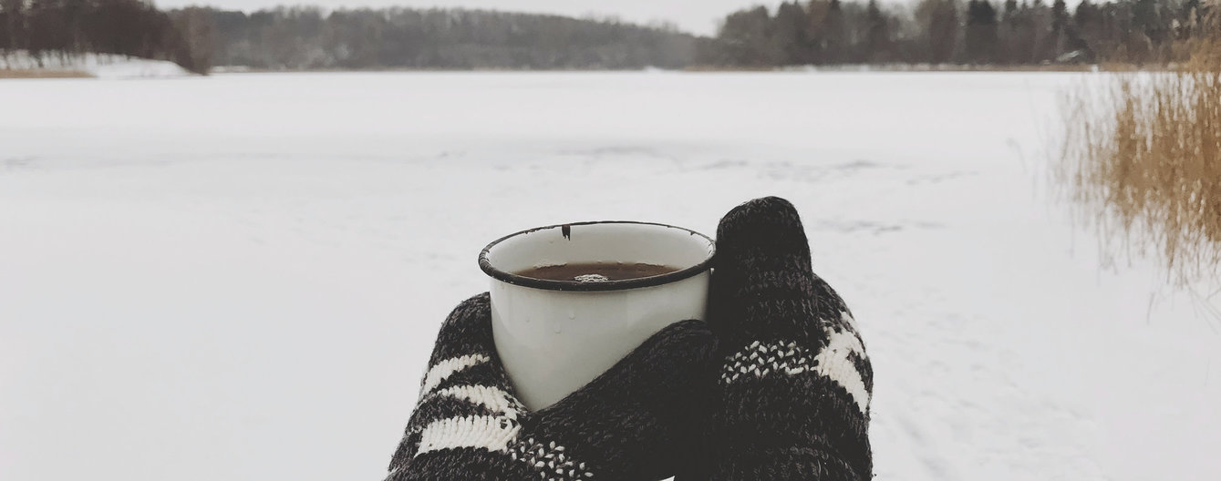 Lockdownabenteuer © iStock in handschuhen eingepackte hände halten tasse tee im winter
