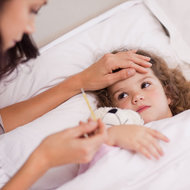 iStock  Mutter kümmert sich um kranke Tochter