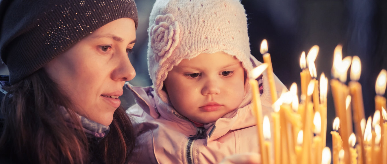 Mutter mit Baby vor brennenden Kerzen