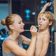 Mutter putzt Sohn die Zähne