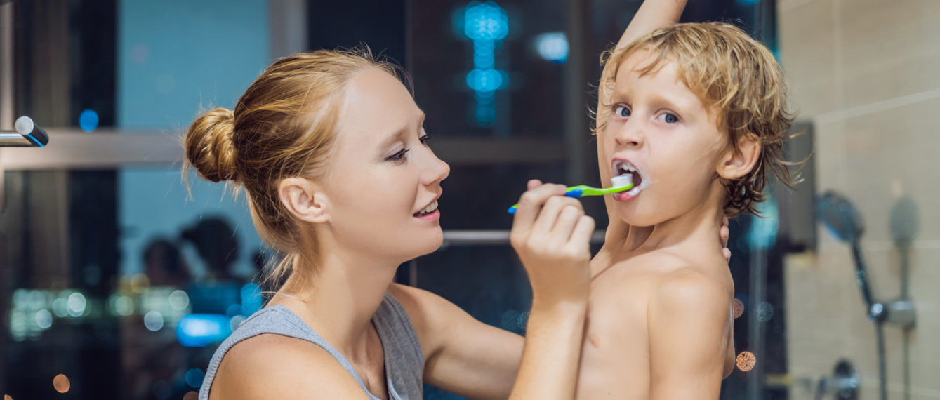 Mutter putzt Sohn die Zähne