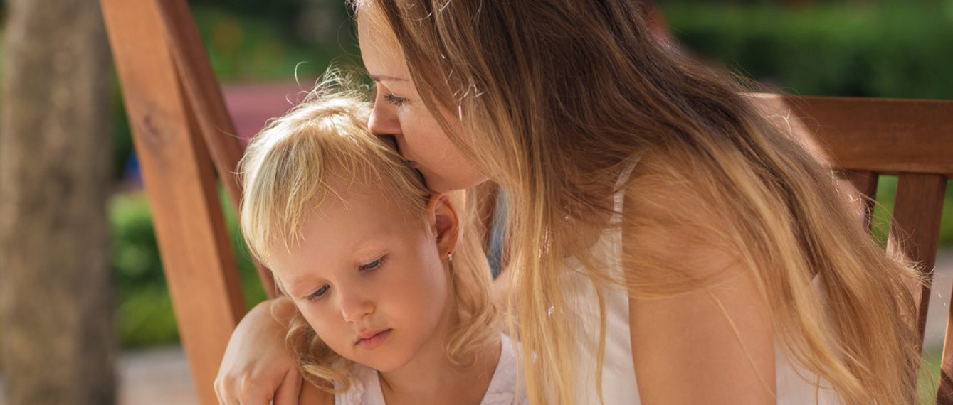 Mutter küsst Tochter im Park