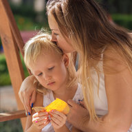 Mutter küsst Tochter im Park